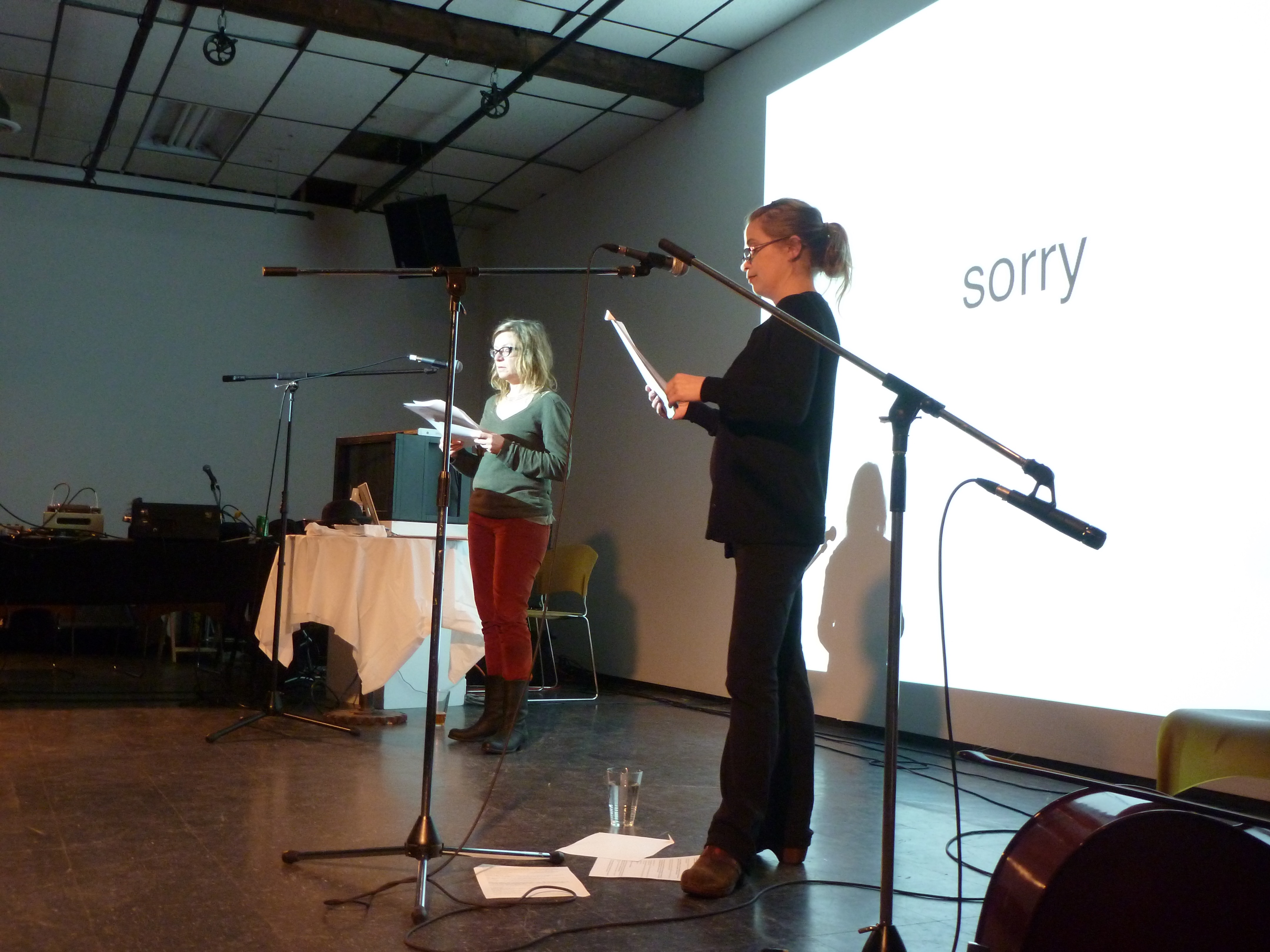 Anakana Schofield and leannej reading at Not Sent Letters in front of a screen projectimg text