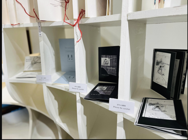 Image of artist books sitting on a book shelf.